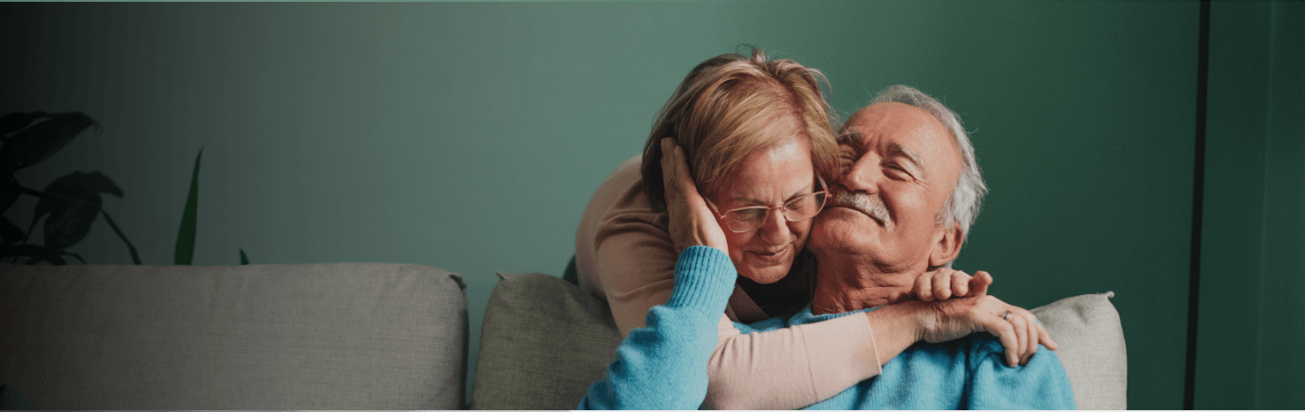 Older couple hugging on a couch